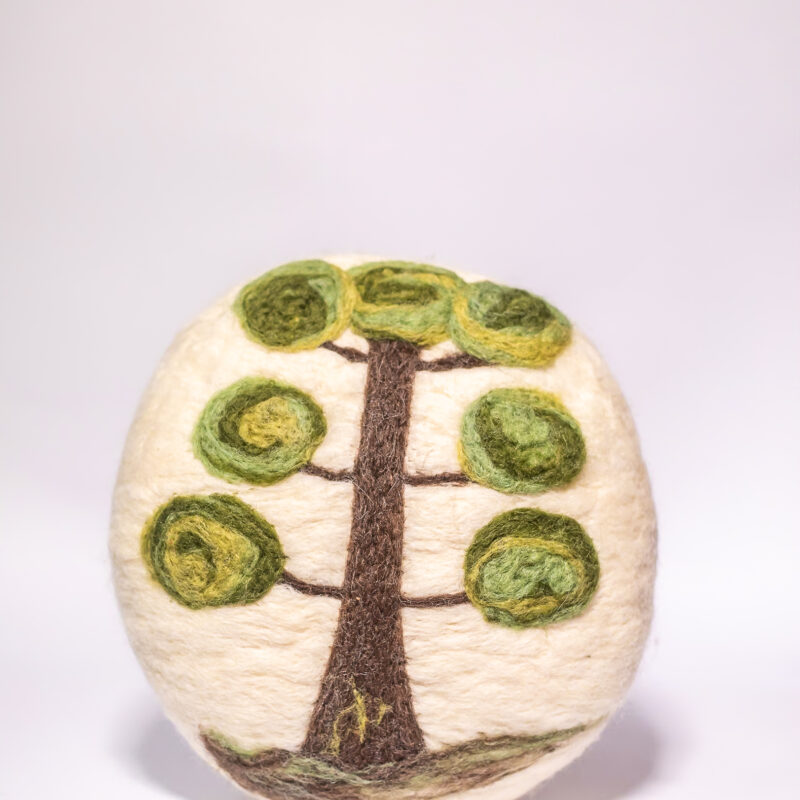 almofada redonda com desenho de araucária feita à mão em feltragem de lã natural pelas artesãs das Mãostiqueiras