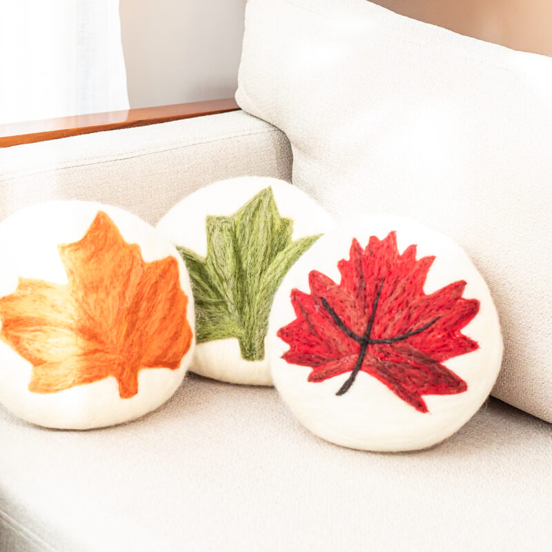 almofada redonda com folha de plátanus feita à mão em feltragem de lã natural sem costura pelas artesãs das Mãostiqueiras