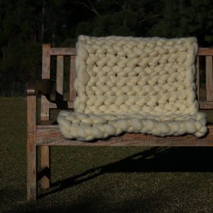 Manta em maxi tricot gigante da lã natural feitas no tricô de braço.