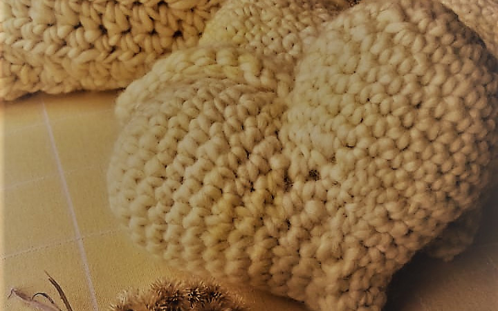 coração artesanal de lã natural tingida com flores de macela, feito à mão em crochet pelas artesãs das Mãostiqueiras