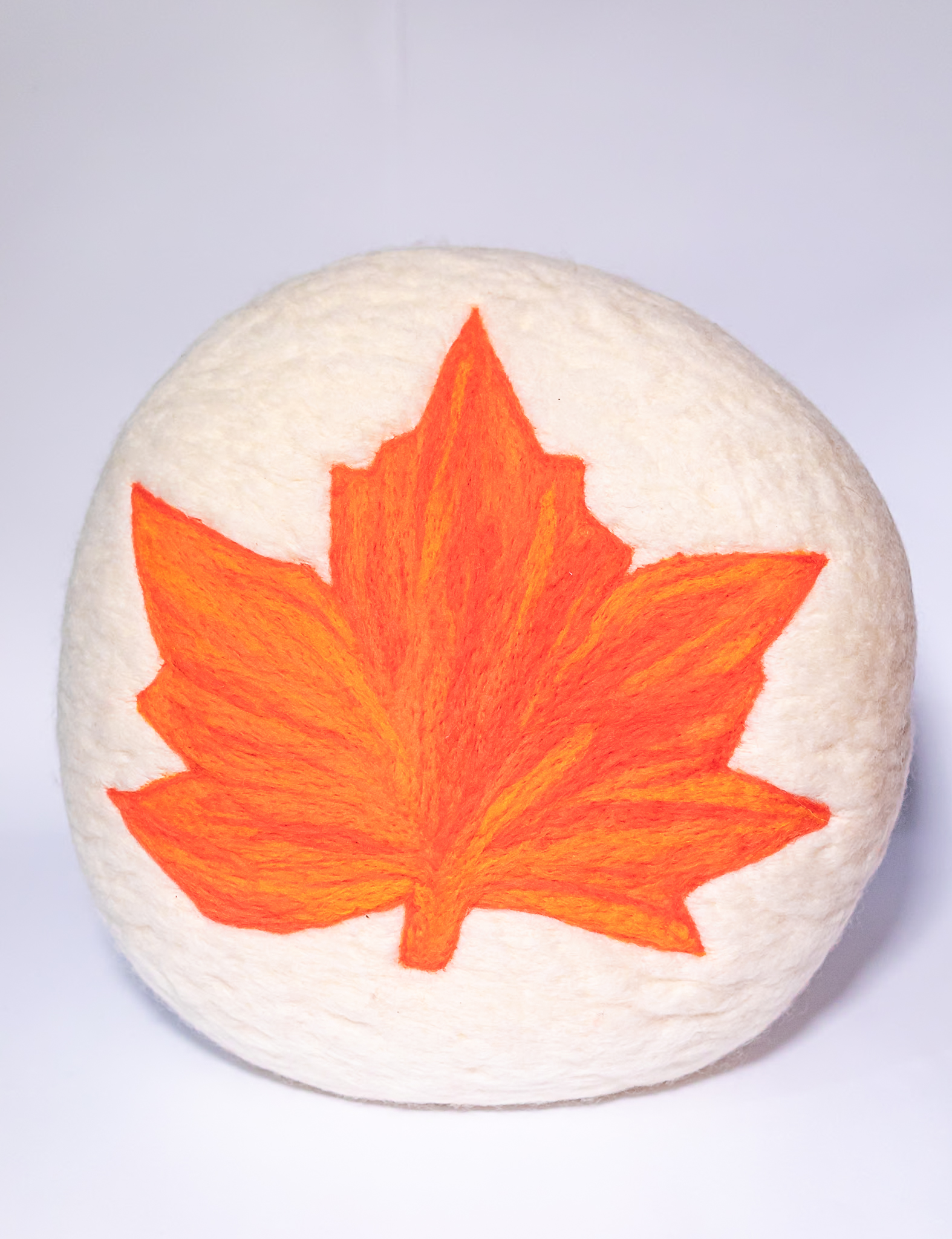 almofada redonda artesanal de feltragem com desenho de folha de plátanus feita à mão em lã natural cardada nas cores inspiradas no outono